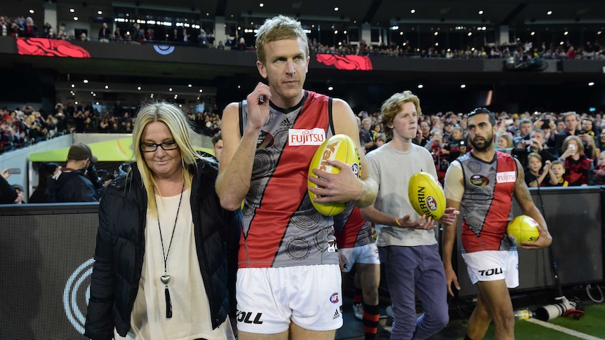 Milestone man ... Dustin Fletcher and his family lead the Bombers out at the MCG