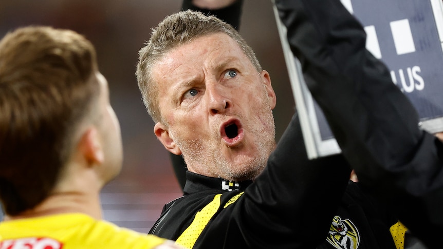 Richmond Tigers coach Damien Hardwick talks to his team during an AFL match against the Essendon Bombers.
