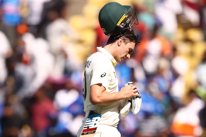 An Australian male batter takes off his helmet after being dismissed in Nagpur.