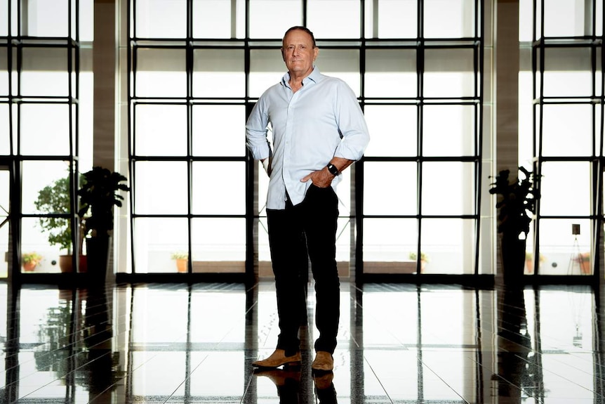 The MP stands in the Great Hall of the NT Parliament building.