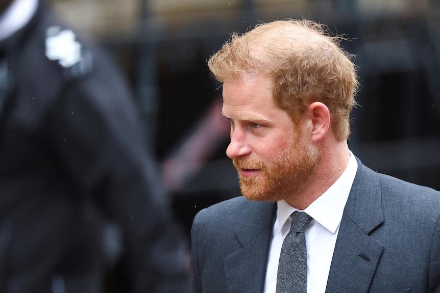 A close up of Harry walking with a neutral expression.