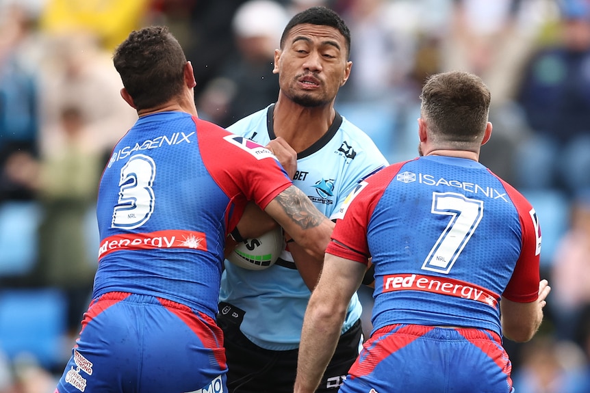 A Cronulla Sharks NRL player makes a hit-up against Newcastle Knights.