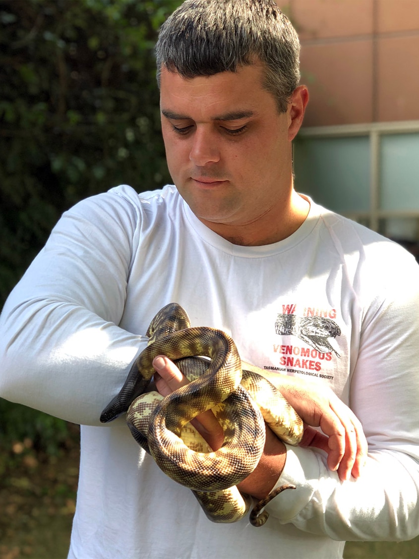 Reptile handler Chris Daly holds a snake