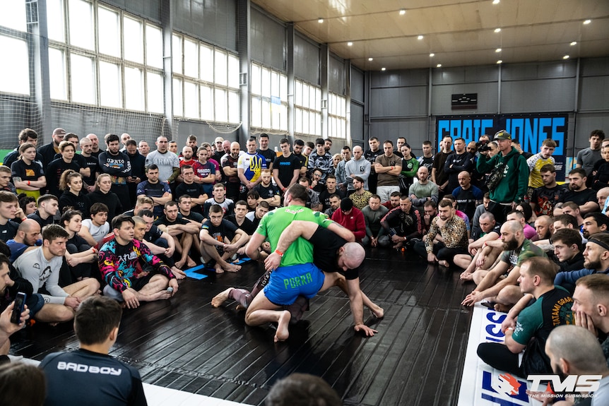 A room of BJJ students in Kyiv, Ukraine. A large poster of Craig Jones is in the background.