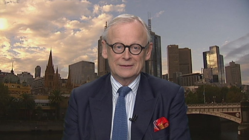 Older man with round glass against a city skyline 