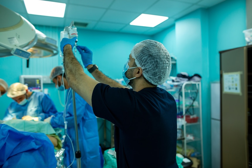 A man seen putting up an IV in the operating room in Gaza.