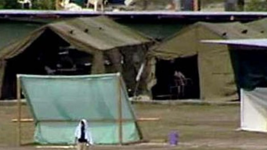 Refugees walk about the detention centre on the island of Nauru