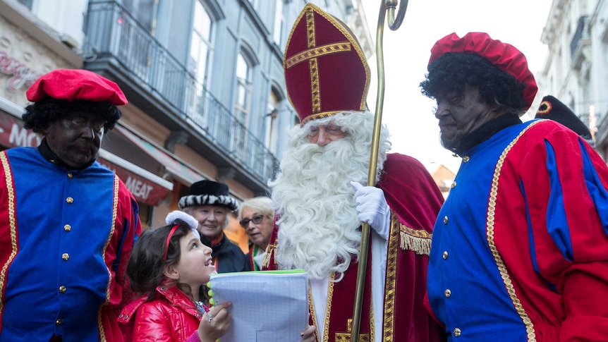 Saint Nicholas is escorted by two assistants known as "Black Pete".
