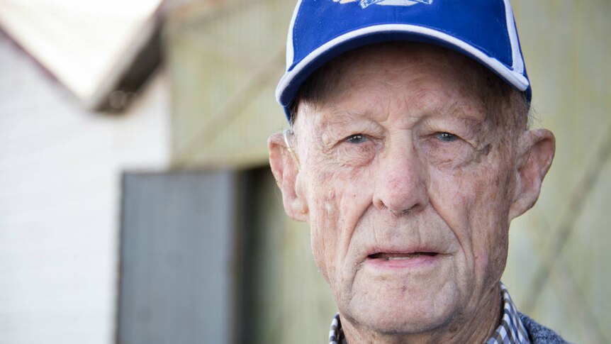 An elderly man wearing a blue cap, looking at the camera.