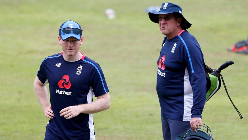 The cricket captain and the coach observe a training session.