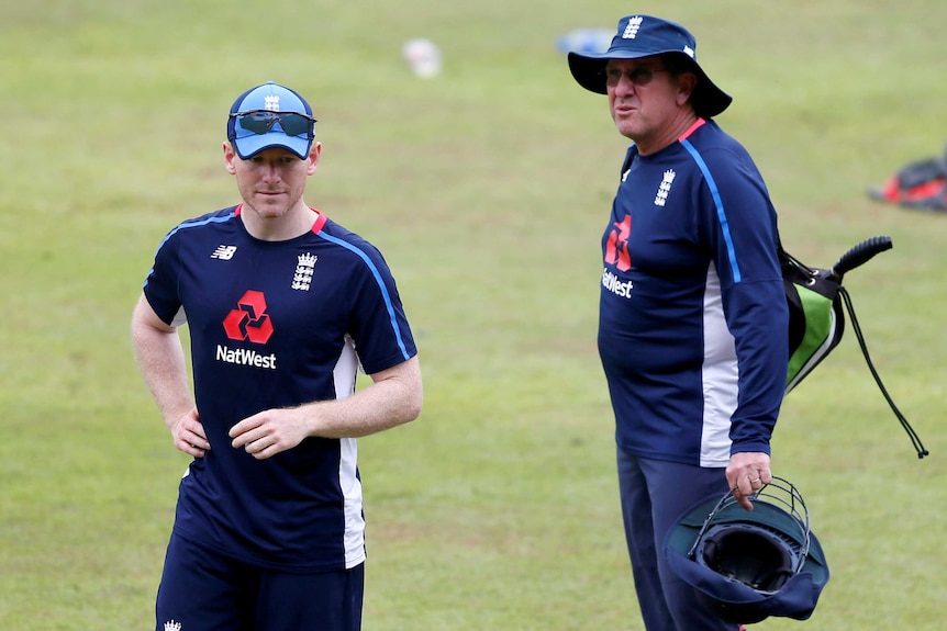 The cricket captain and the coach observe a training session.