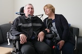 Chris English sits in a wheelchair with his wife Bobbie sitting next to him.