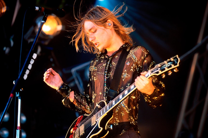 Daniel Jonhns performs in black and silver sheer shirt 