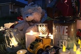 Toys and flowers are left at a candle-lit vigil in Jacka for a boy who died this week.