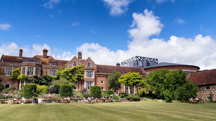 Glyndebourne Manor House and gardens, with the opera theatre roofs showcasing an amalgam of old and new. (Glyndebourne Festival: John Bellorini)
