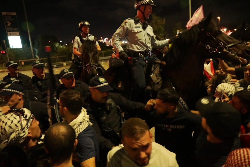 Two police on horseback amid people at pro-Palestinan rally at Port Botany 