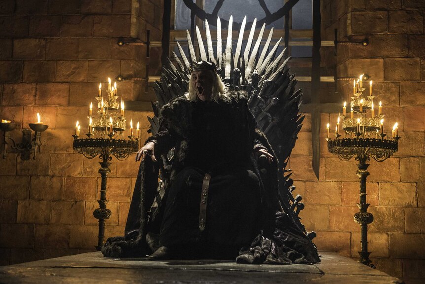 King Aerys II sitting on the Iron Throne screams to 'burn them all'.