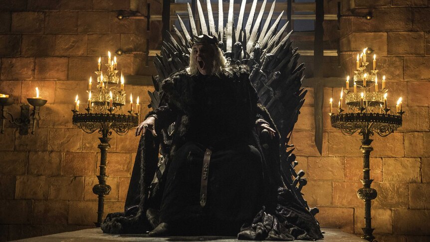 King Aerys II sitting on the Iron Throne screams to 'burn them all'.