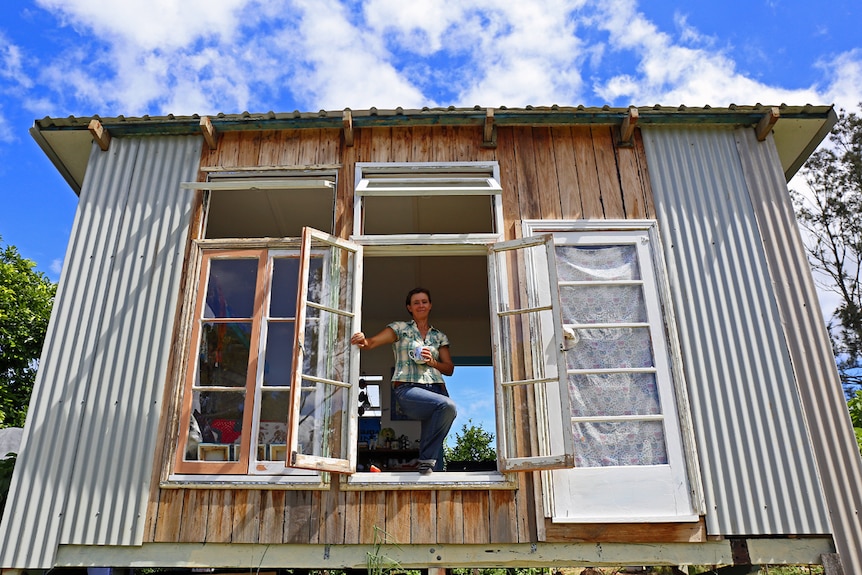 Jo Nemeth looks out the window of her shack, pictured in story about living without money.
