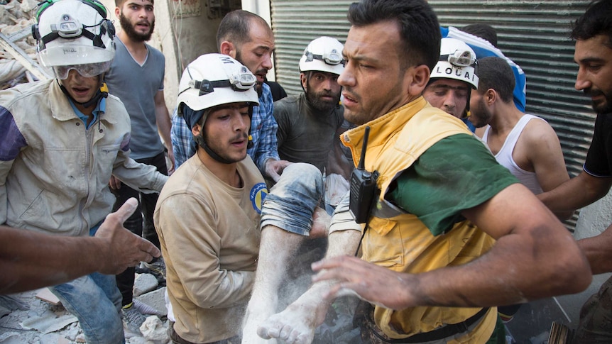 Syrian civil defence volunteers, known as the White Helmets, carry a body in Aleppo.