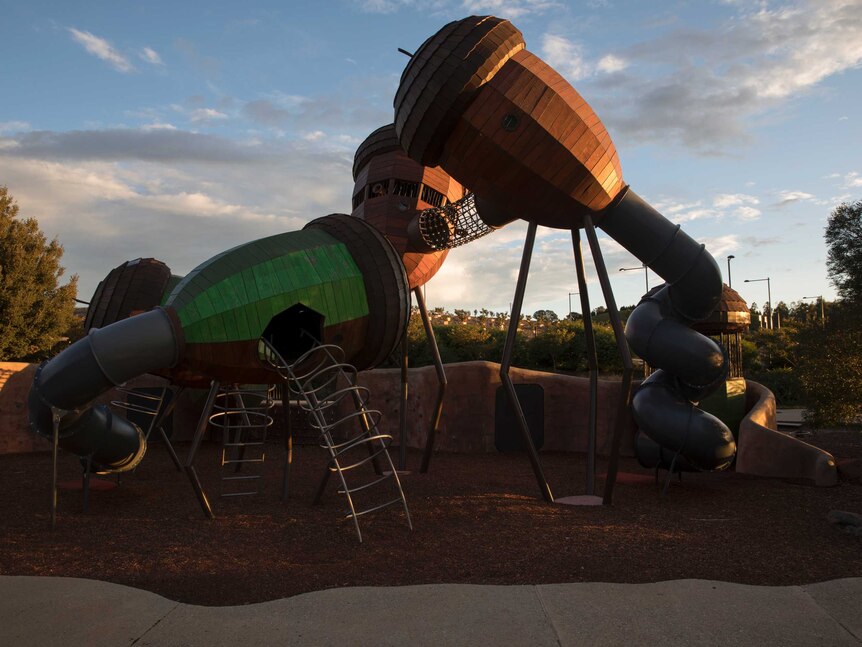 An empty playground in Canberra lit by the golden evening sunlight