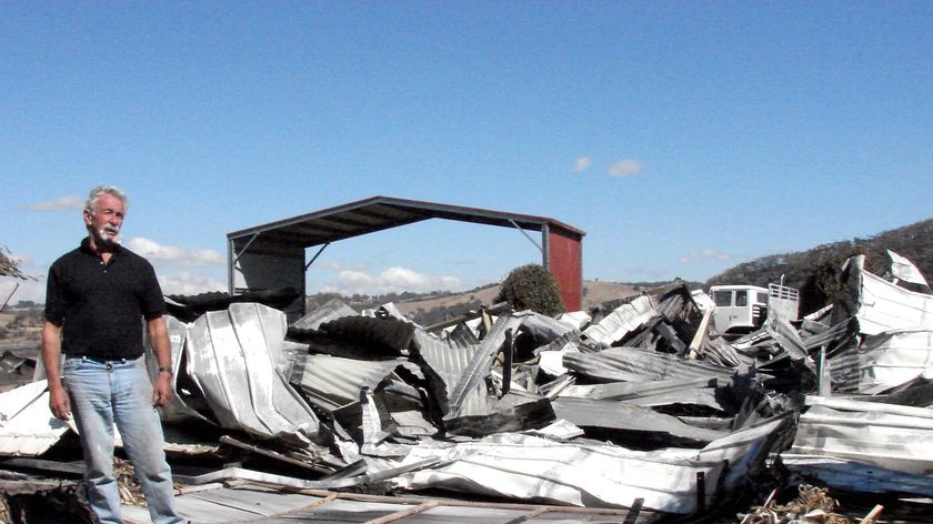 Max Pickering stands next to what's left of his property