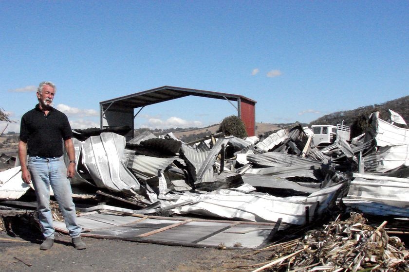 Max Pickering stands next to what's left of his property