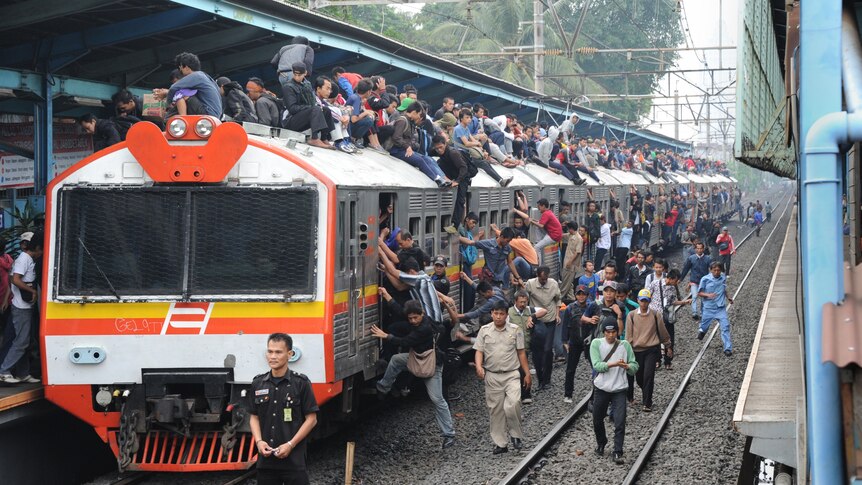 A train loaded with passengers arrives at the Tebet station in Jakarta during rush hour