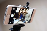 An iPhone on a selfie stick.