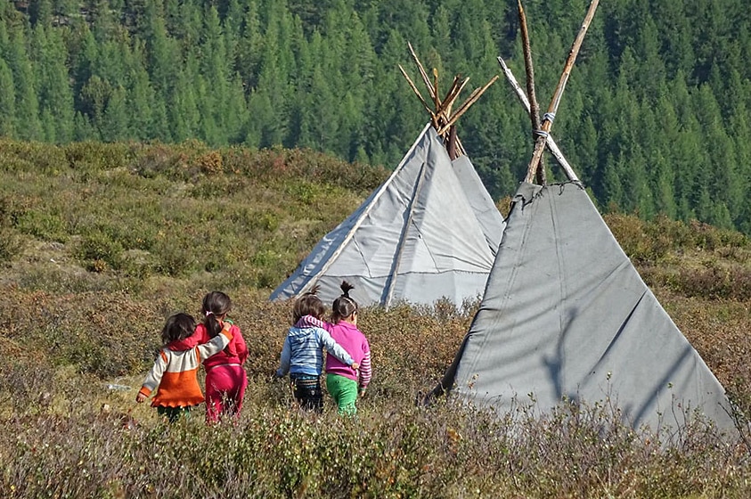 Children of the reindeer people head to the family teepees