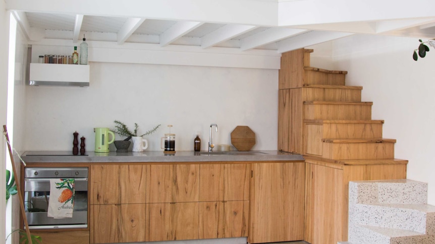 A mezzanine and small staircase create a second floor bedroom.