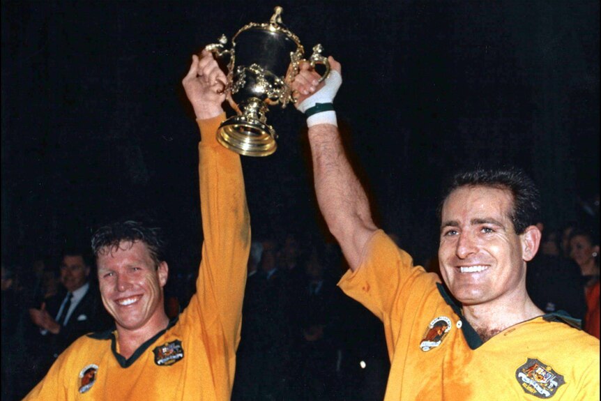 World beaters ... Nick Farr-Jones (L) and David Campese hold aloft the Webb Ellis Cup