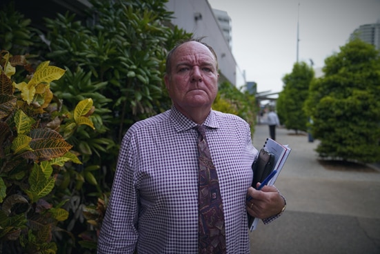 A man stands defiant with documents in hand.