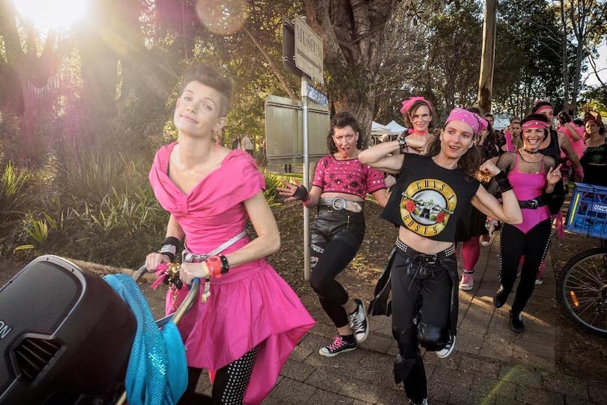 Marissa Treichel marches ahead of The Cassettes in pink and black 1980s costumes