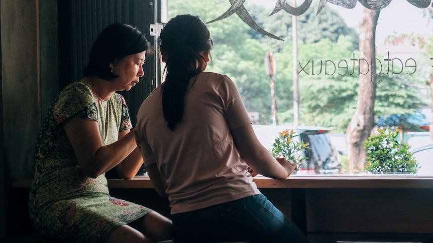 Two women at a bench in a cafe for a story about the importance of an aunty/older women in girls' lives