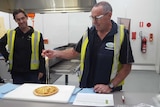 Stanhope-based cheese technician Paul Triste uses a fork to lift melted mozzarella from a freshly-baked pizza.