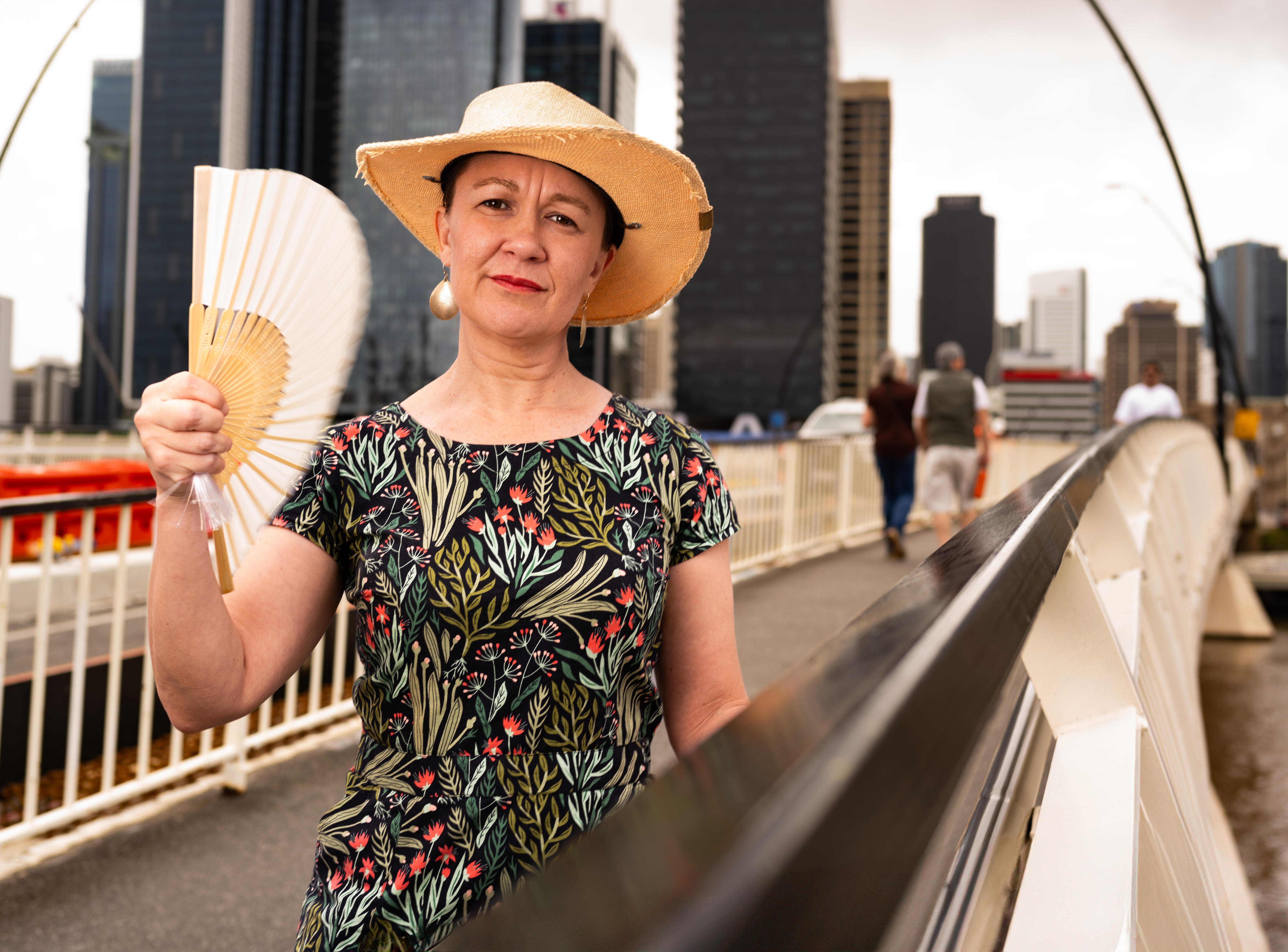 A woman with a fan and a sun hat