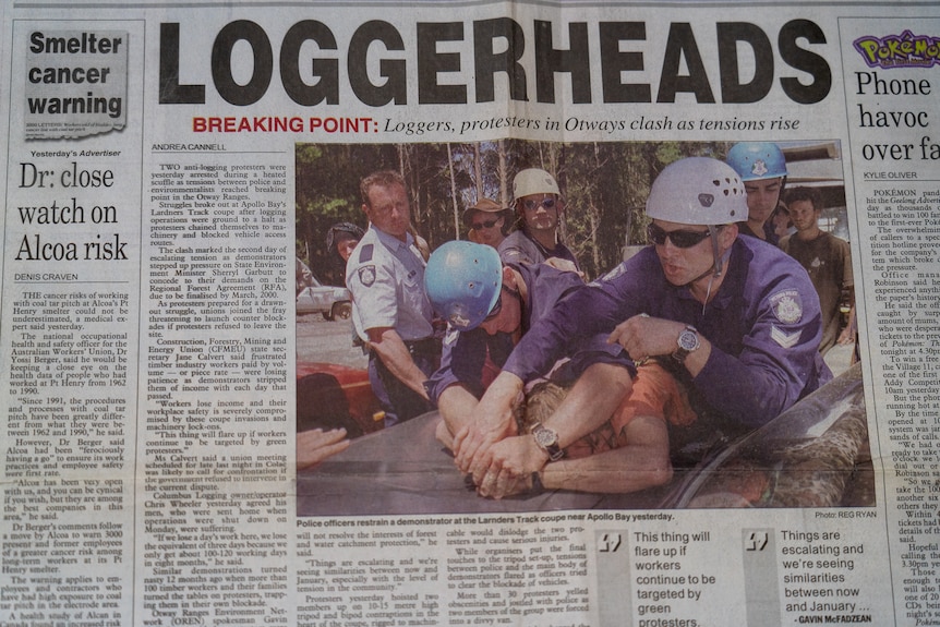 A photo in a newspaper showing a protester being arrested.