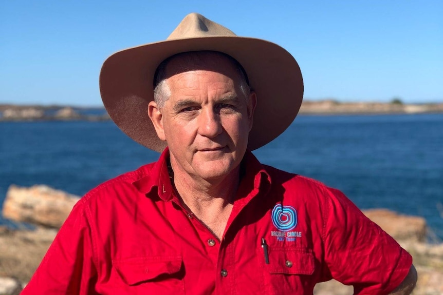 Financial counsellor Alan Gray stands in front of the beach.