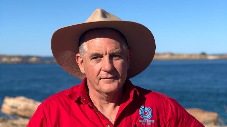 Financial counsellor Alan Gray stands in front of the beach.