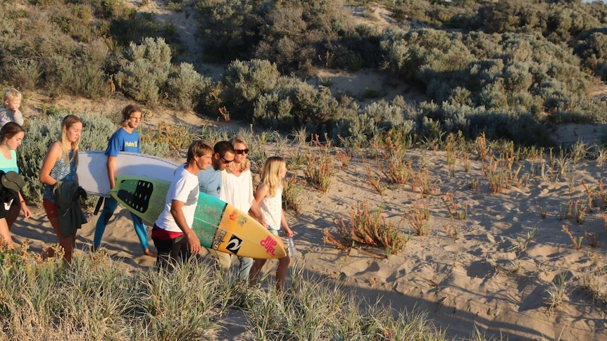 Julie and Leon Brouwer arrive at Singleton Beach carrying surfboards
