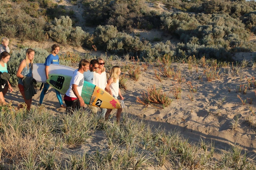 Julie and Leon Brouwer arrive at Singleton Beach carrying surfboards