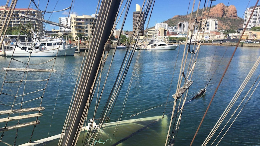 The masts of tall ship Defender showing, with the rest of the ship underwater.