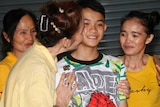 Relatives of Duangpetch Promthep greet him as he arrives home in the Mae Sai district.