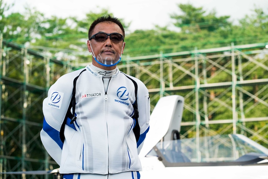 A man in a flight suit stands next to