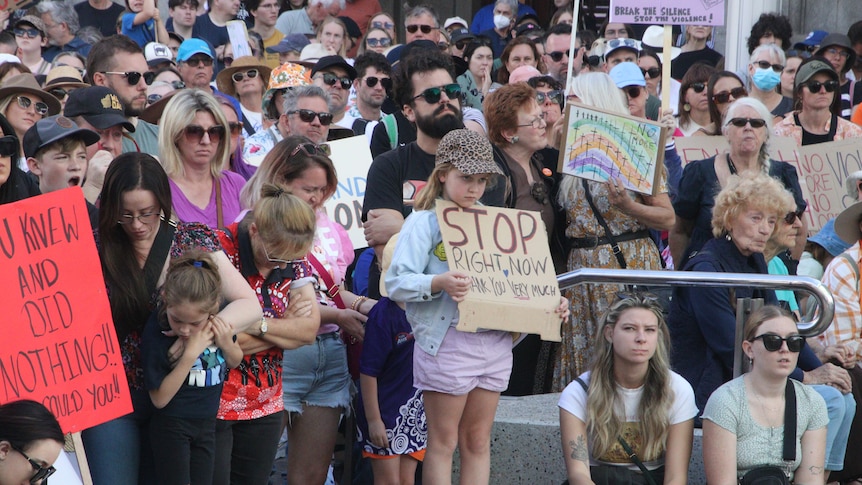 Children and adults holding anti-violence signs at the Perth rally.