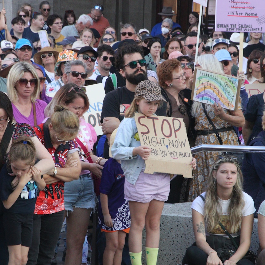 Children and adults holding anti-violence signs at the Perth rally.