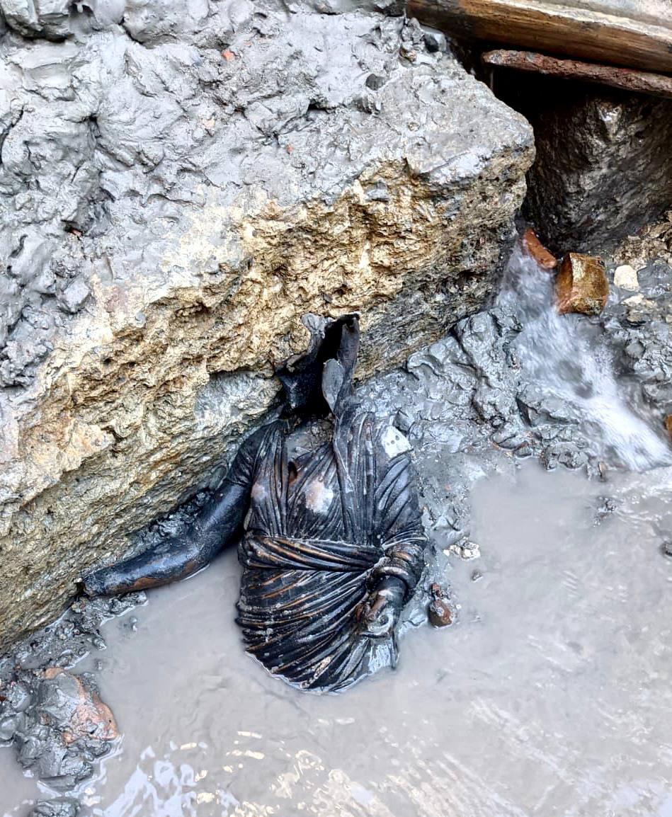 O statuie de bronz recent descoperită, situată într-o băltoacă de apă noroioasă