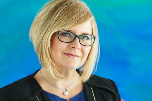 Former Black Swan executive director Natalie Jenkins in front of a blue painting.