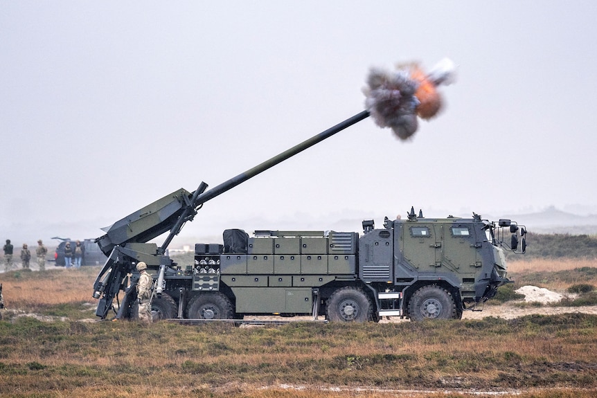 A view of a vehicle with large gun firing.